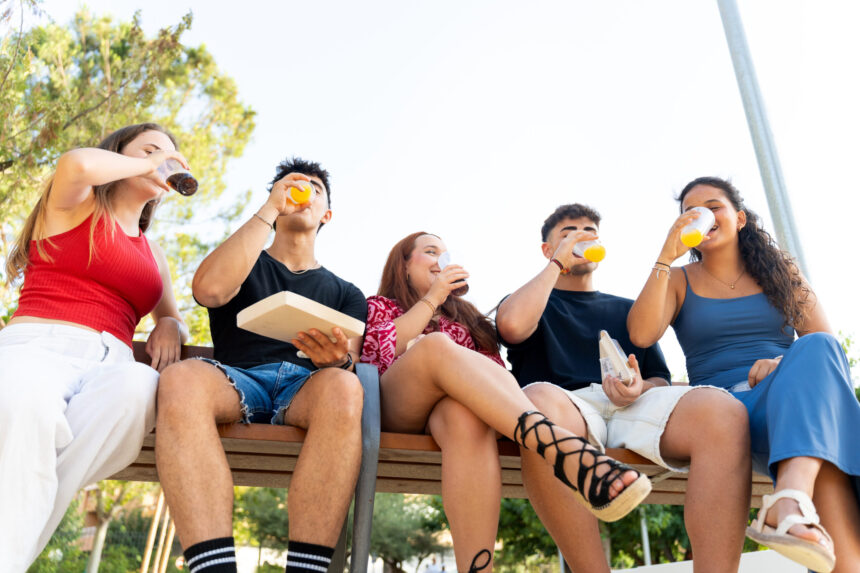 Group of young adults enjoying drinks and socializing outdoors Energy Drink and Teen Heart Health
